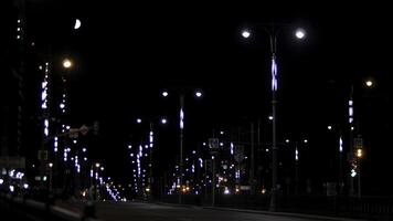 Empty residential street in the late evening with road signs and lanterns on black sky background. Stock footage. Night urban street lit by neon lights. photo