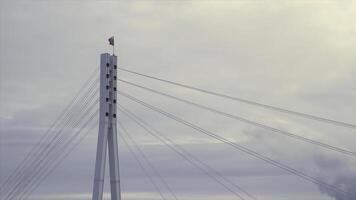 Russian Federation flag fluttering in the wind on the top of the bridge. Stock. Russian flag on the top of a bridge on grey, cloudy sky background. photo