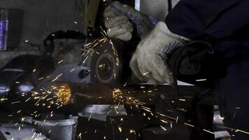 Male hand cuts off pieces of water pipe with angle grinder. Cutting of a steel with splashes of sparks at construction site. Sparks during cutting of metal angle grinder photo