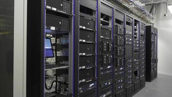 Many powerful servers running in the data center server room. Many servers in a data center. Many racks with servers located in the server room. Bright display a plurality of operating equipment. photo