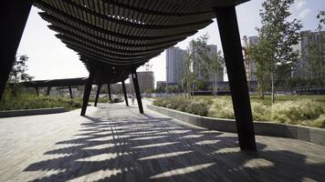 Modern pergolas in park on sunny day. Action. Long pavilions or pergolas in modern city park. Beautiful architectural solutions for recreation areas in park photo