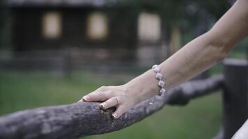 Close-up of bride's hands with on beautiful white wedding dress. Clip. Newlywed girl in outdoor near wooden fence photo