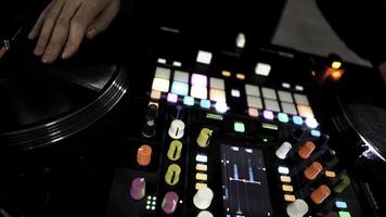 cerca arriba de DJ utilizando un moderno sonido mezclador para jugando electro música a el Club nocturno. Arte. vistoso botones y vinilo, equipo de un DJ. foto
