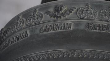 Bottom view of a large church bell details. Stock footage. Close up of an ancient iron bell on blurred background, concept of religion and history. photo