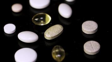 Pills spinning. Pile of several medicines. White tablets with pills on black background. Opened medicine capsule pill photo