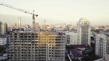 Construction site with cranes. Video. Construction workers are building. Aerial view. Top view of the construction site in the city. Construction in the city with a crane manipulator photo