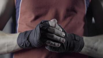 Man flexing his fists before a fight. Close-up of a young Thai boxer hands hemp ropes are wrapped before the fight or training photo