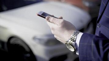 Close-up of businessman pressing car key. Action. Businessman opens car with electronic key and looks at phone. Modern car key to open and start it photo