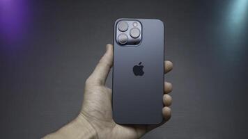 China, Beijing - September 15, 2023. Design of new iPhone 15 pro. Action. Stylish model of new iPhone 15 pro in lucky man's hands. Luxury design of new iPhone 15 pro on isolated background photo