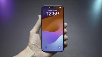 Close-up of phone screen with time. Action. Stylish phone lock screen saver. Man holds stylish phone with screen turned on on isolated background photo