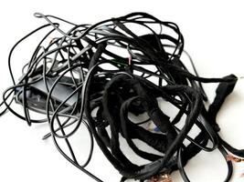 Tangled roll of black wires isolated on white background. Clip art. E-waste mess concept. photo