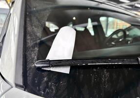 Parking fine ticket left on car dirty window after rain or snow. Place for text. photo