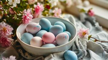 ai generado un blanco cuenco lleno con azul y rosado huevos sentado en parte superior de un mesa siguiente a un manojo de flores foto