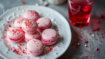 AI generated A white plate topped with lots of pink macaroons next to a glass of red liquid and sprinkles photo