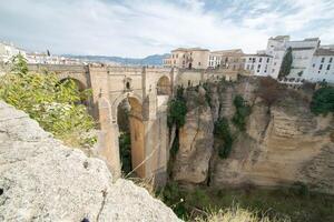 a view from atop one half of cliff faces separating the pueblo of Ronda in Andalucia photo