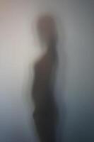 Side View of Woman Silhouette Behind Frosted Glass photo