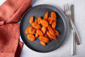 Baked carrots lie on a plate. photo