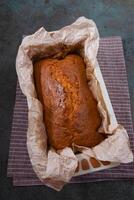 Fresh cake baked in a cake pan on parchment paper. Homemade baking photo