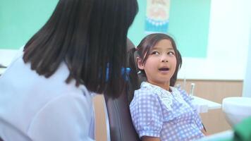 een klein schattig meisje met tanden onderzocht door tandarts in tandheelkundige kliniek, tandencontrole en gezond gebit concept video