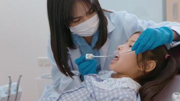 A little cute girl having teeth examined by dentist in dental clinic, teeth check-up and Healthy teeth concept video