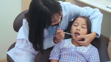 een klein schattig meisje met tanden onderzocht door tandarts in tandheelkundige kliniek, tandencontrole en gezond gebit concept video