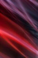 Abstract vertical red background with diagonal smooth lines waves. Light and rays are blurred in motion. photo