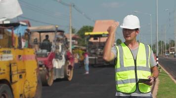 asiatique ingénieurs regarder route reconstitution ouvriers et asphalte Machines de le route à le construction placer. video