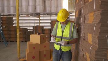 Porträt von asiatisch Ingenieur Mann bestellen Einzelheiten Überprüfung Waren und Karton Box mit Waren Hintergrund im Lagerlogistik und Geschäft Produkt exportieren Verteilung Logistik Center. video
