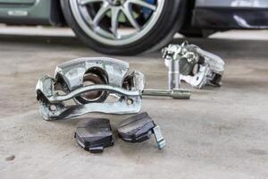 Single port caliper and brake pad on floor and car service part and service concept photo