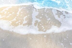 Sea wave and bubble on a sandy white beach blue sea background texture and copy space photo