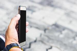 mano un hombre vídeo llamada con familia en inteligente teléfono y difuminar antecedentes Copiar espacio textura foto