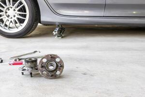 Wheel bearing and tool on the cement floor in service shop and jack for level adjust photo