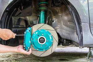 Hand and man remove nut lock caliper pad on the caliper brake repair concept and maintenance of car photo