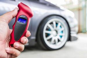 Close up Tire gauge digital and hand a man use for check air pressure of wheel car basic maintenance photo