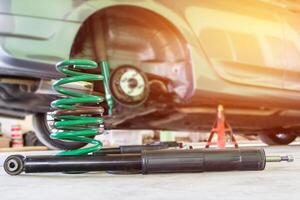 Chang Coil spring and shock absorber on the service shop change and remove old part car maintenance concept photo