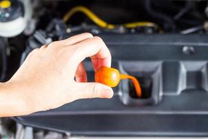 Hand a women check level of engine oil in the engine room basic service of car concept photo