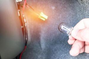 Close up Light bulb of Car and hand a man change and maintenance ramp of brake system signal photo