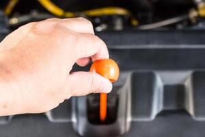 Hand a man check level of engine oil in the engine room basic service of car concept photo