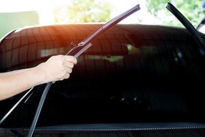 Hand a man change rubber the wiper of glass car in garage shop service and maintenance in rainy season photo