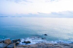 Nature view for soft wave and stone in the sea in morning for background and texture photo