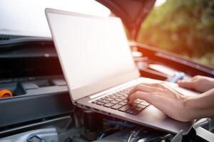 Close up hand Technician use computer Analyze car problems The parking lot on the side of the road photo