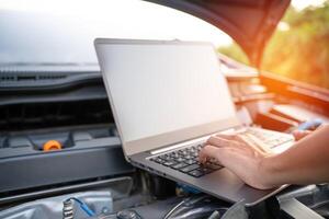 cerca arriba mano técnico utilizar computadora analizar coche problemas el estacionamiento lote en el lado de el la carretera foto