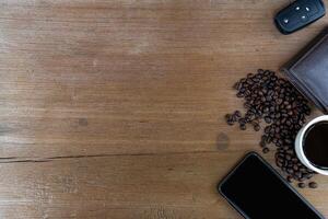 Top view of coffee cub coffee bean smart phone car key and wallet on wood table for texture and copy space photo