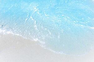 Sea wave and bubble on a sandy white beach blue sea background texture and copy space  holiday concept photo