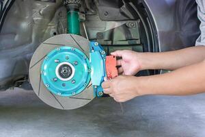 Hand A man adjust bolt for unlock brake pads to change in basic service concept of car with run stop system photo