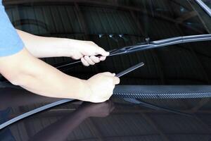 Hand Technician change rubber the wiper of glass car in garage shop service and maintenance in rainy season photo