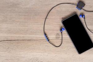 Smart phone and bluetooth headset on wood floor background healthcare and relax concept photo