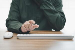Business Man pushing on a touch screen interface action and keyboard mouse desktop on the table photo