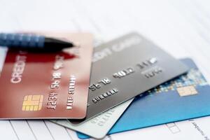Close up credit cards on insurance document for payment of Annual insurance expenses that must be paid regularly instead of using cash photo