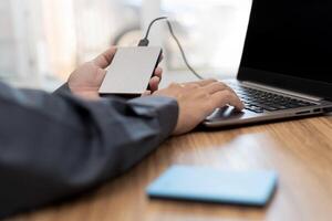 External backup disk in hard a man connected to laptop computer safety personal data copy Prevent data corruption in the computer system photo